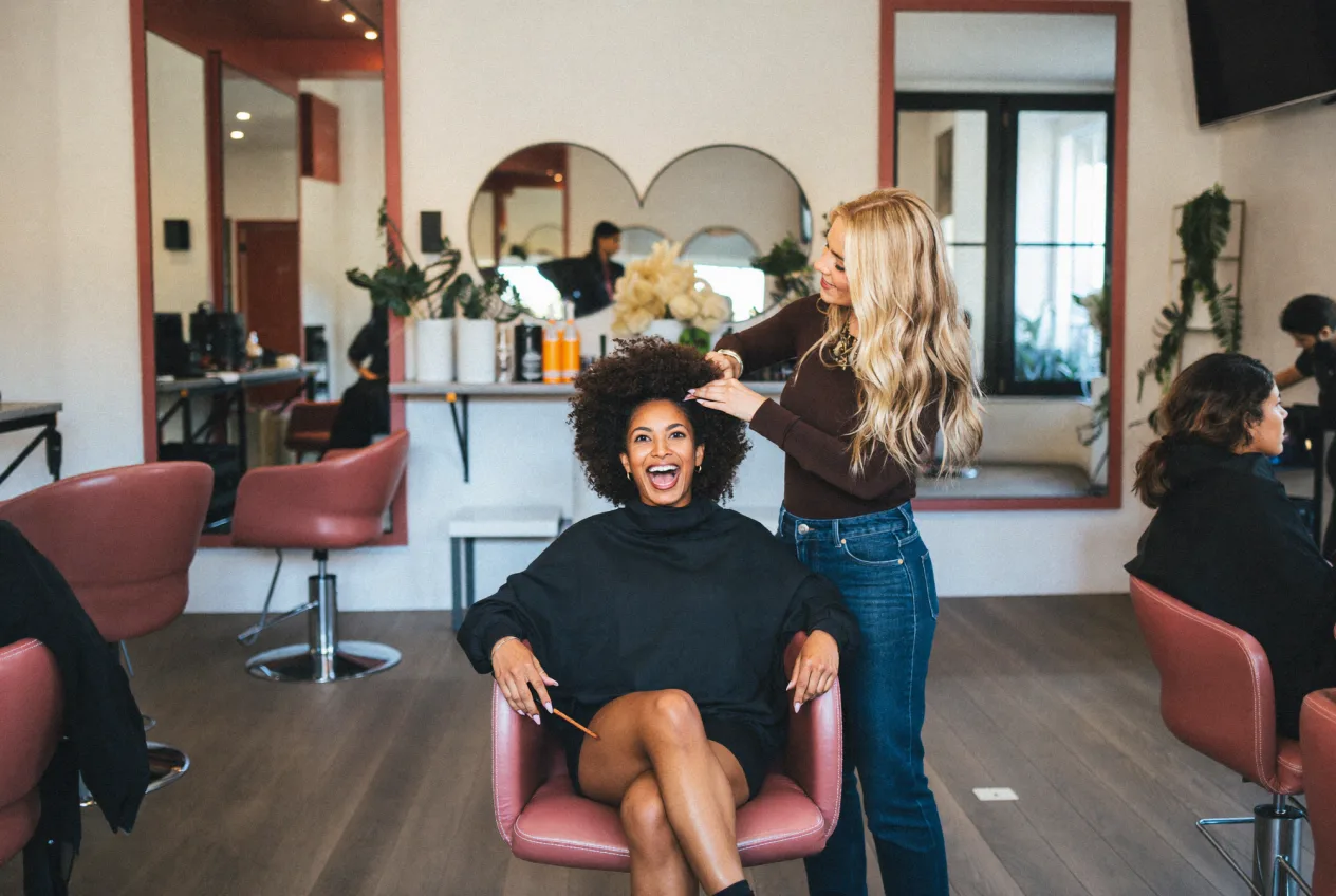 Friseurin stylt einer Kundin die Haare im Salon