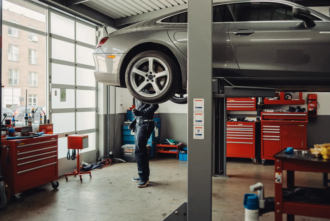 Mechatroniker arbeitet konzentriert an einem Fahrzeug auf der Hebebühne