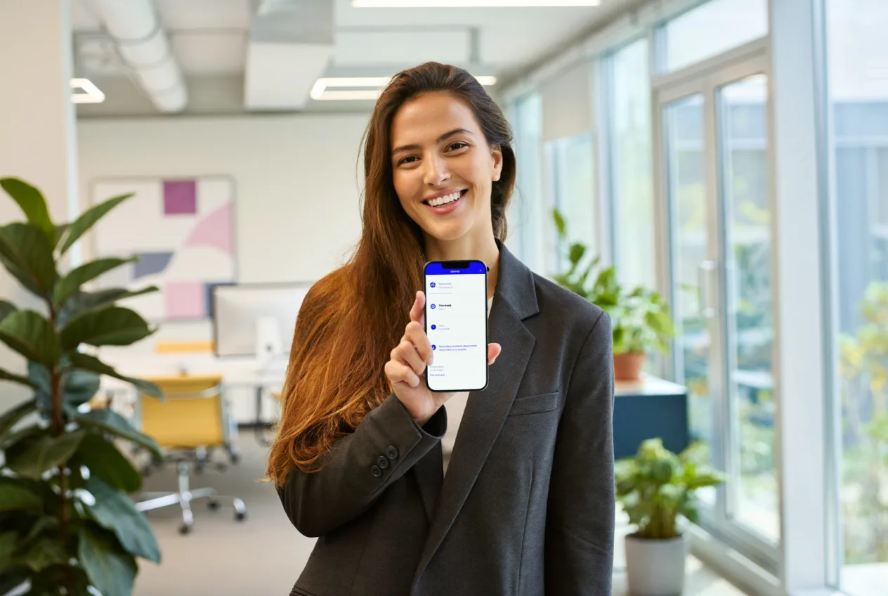 Smiling woman presenting the finished custom app on her smartphone – software development by NK IT Service